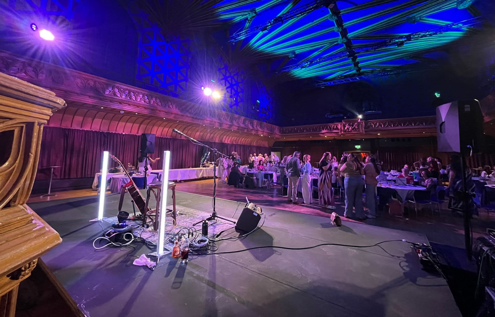 View from the stage of a large ballroom lit blue and purple during a corporate function